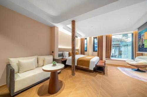une chambre d'hôtel avec un lit et un canapé dans l'établissement 三间堂百年徽商俞家 婺源月亮湾店, à Wuyuan