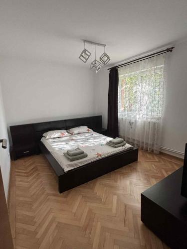 a bedroom with a bed and a large window at Wine Road Apartment in Gura Vadului