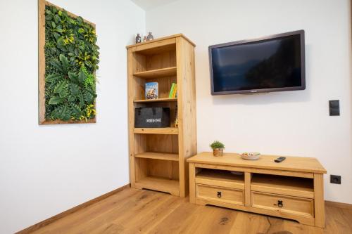 een woonkamer met een tv en een houten tafel bij Bichler's Alpennest in Maurach