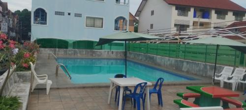 a patio with a table and chairs and a pool at SleeproomsHuahin in Hua Hin