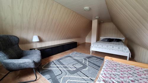 LeimaniにあるPlagandõ puhkemajaのベッドと椅子と敷物が置かれた屋根裏部屋