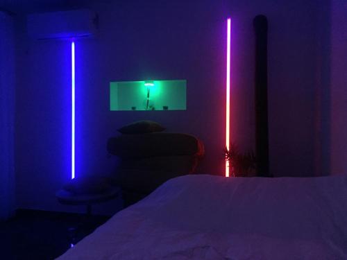 a bedroom with purple and blue lights and a bed at River Side Apartment in Prizren