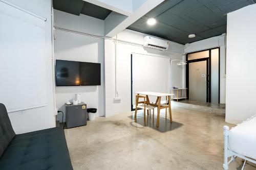 a living room with a table and a tv at X Yellow Place Sukhumvit Soi 2 BTS Nana - เยลโล เพลส สุขุมวิท ซอย 2 บีทีเอส นานา in Bang Kapi
