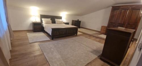a bedroom with a bed and a dresser and two rugs at Kytila Apartments in Chitila