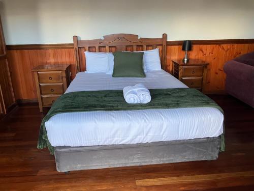 a bedroom with a bed with two towels on it at Highlander Van Village in Armidale
