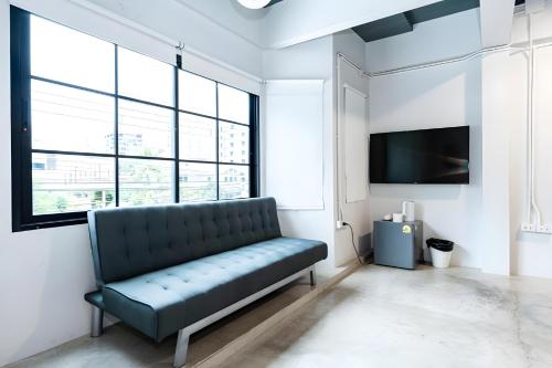a living room with a couch and a tv at X Yellow Place Sukhumvit Soi 2 BTS Nana - เยลโล เพลส สุขุมวิท ซอย 2 บีทีเอส นานา in Bang Kapi
