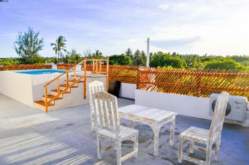 a patio with two chairs and a table and a pool at Mangrove Sunset Villa in Watamu