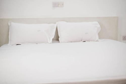 two white pillows sitting on top of a bed at Mangrove Sunset Villa in Watamu