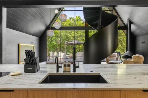 cocina con fregadero y ventana grande en Midnight Raven Lake House - luxury a-frame w boat, en Reed Creek