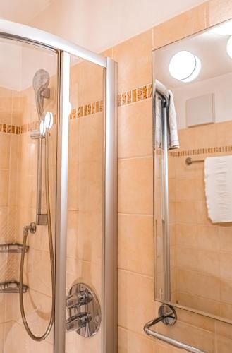 a shower with a glass door in a bathroom at Garni Eden in Canazei