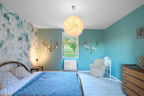 a blue bedroom with a bed and a window at Maison Tiny Bwa in Saint-Cernin-de-lʼHerm