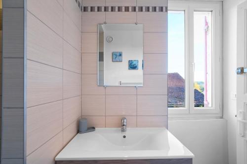 a bathroom with a sink and a window at Maison Tiny Bwa in Saint-Cernin-de-lʼHerm