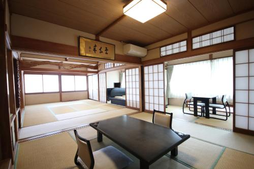 a room with a table and chairs in a room at 塵表閣本店 in Yamanouchi