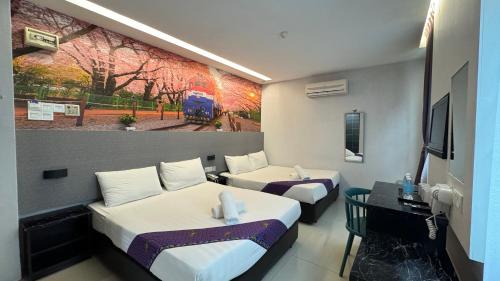 a hotel room with two beds and a painting on the wall at Best View Hotel Puchong in Puchong