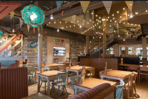 a restaurant with wooden tables and chairs and a staircase at 27 Ivy Close in Mablethorpe