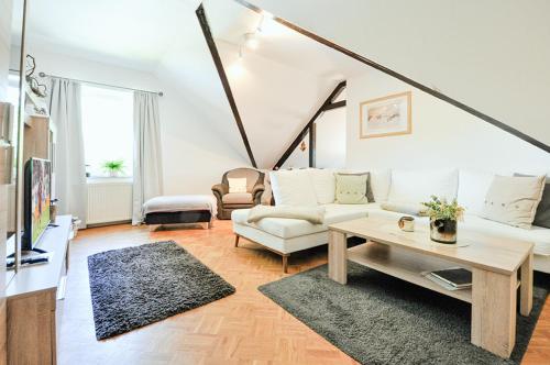 a living room with a white couch and a table at Ferienwohnung KonradAlbrecht in Torgelow am See