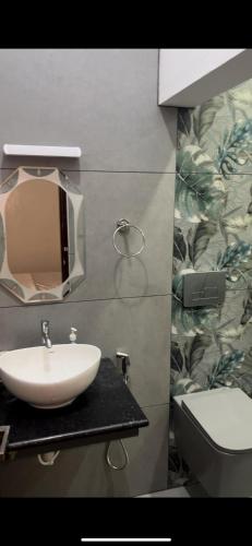 a bathroom with a sink and a toilet and a mirror at Vembanad Ripples in Alleppey