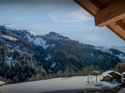 vistas a una montaña con nieve y árboles en Chalet Le Charmieux - OVO Network, en Le Grand-Bornand