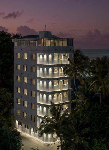 a tall building with lights on it at night at Nest by Hawks Hotels Kamadhoo Baa Atoll in Kamadhoo