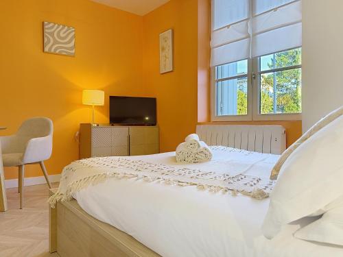 a bedroom with a white bed with a window at Teeny Ponta Plage in Royan