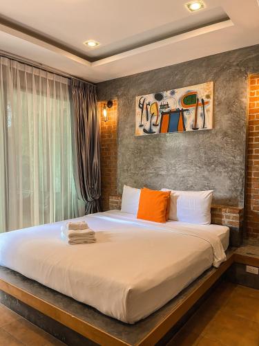 a bedroom with a large white bed with orange pillows at BaanMee Phuket near Chalong Pier in Chalong