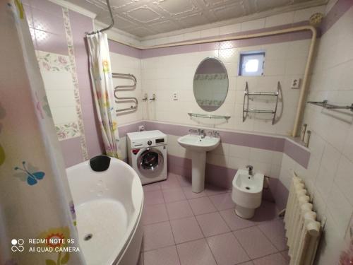 une salle de bain avec un lavabo et une machine à laver dans l'établissement Hostel "OrmaNOVA", à Almaty