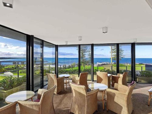 a room with chairs and tables and windows at ibis Styles Port Macquarie in Port Macquarie