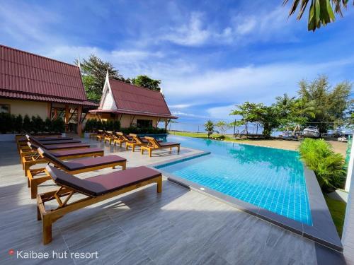 a swimming pool with lounge chairs and a resort at Kaibae Hut Resort in Ko Chang