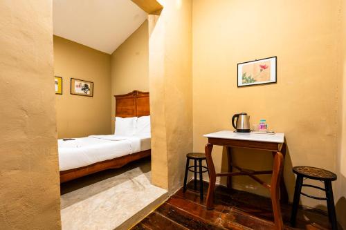 a bedroom with a bed and a table with two stools at Rest Inn Yaowarat เรสอินน์ เยาวราช in Samphanthawong