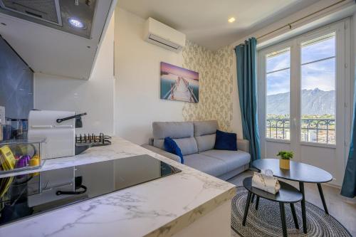 a kitchen and living room with a couch and a table at Aix-Riviera - 30min d'Annecy in Aix-les-Bains