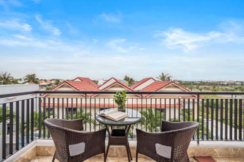 a patio with a table and chairs on a balcony at ELC Boutique Hoi An Hotel in Hoi An