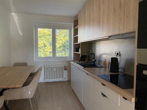 a kitchen with white cabinets and a wooden counter top at Apartmán Sihoť - pri Zimnom Štadióne in Trenčín