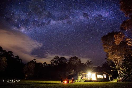 a group of people standing in a field under a night sky at Nightcap Ridge - Byron Bay Hinterland in Dorroughby