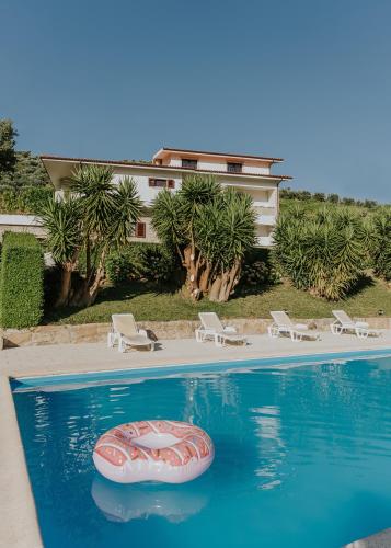 a swimming pool with a red raft in the water at Jerónimos Garden & Pool Villas in Lamego