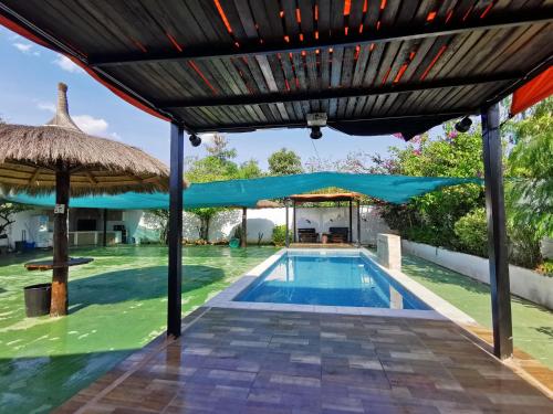 una imagen de una piscina bajo una pérgola en Casa mono ambiente y piscina., en Limpio