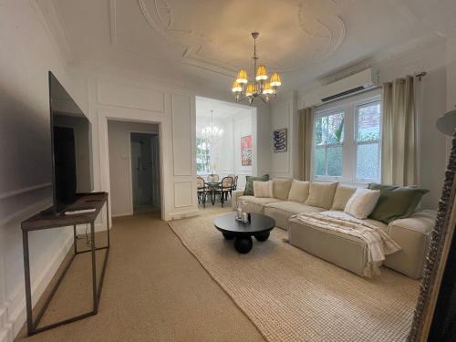 a living room with a couch and a table at Luxury heritage Hideaway - close to CBD! in Sydney