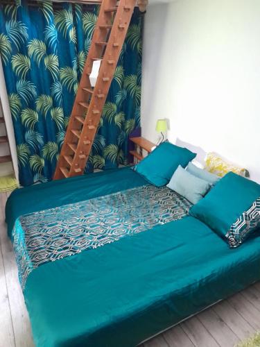 Una cama en una habitación con una escalera encima. en La Suite Richarvilloise, en Richarville