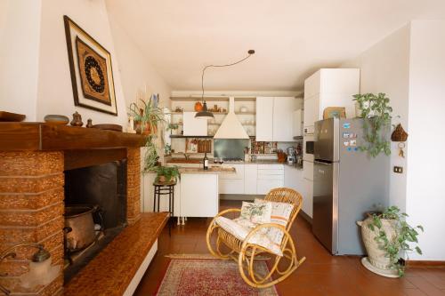 a kitchen with a fireplace and a refrigerator at Corte L'Ovo - Country House 15 minutes from the heart of Verona in Grezzana