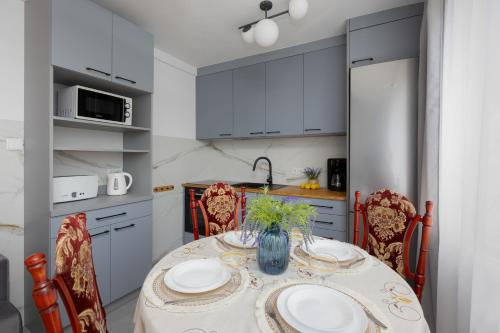 a kitchen with a table and chairs and a kitchen with white cabinets at Spacious Apartment Close to Warsaw for 5 people by Noclegi Renters in Konstancin-Jeziorna