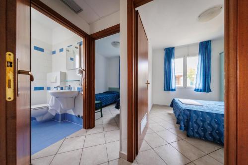 een badkamer met een bed en een wastafel in een kamer bij Villaggio Turistico La Cecinella in Marina di Cecina