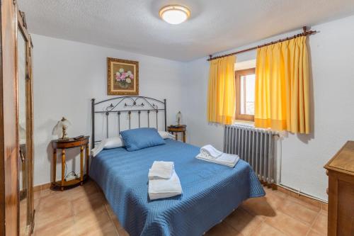 a bedroom with a blue bed with two towels on it at Casa De Los Abuelos in Ortigosa del Monte