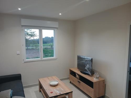 a living room with a table and a window at La pause enchantee in Villarcoin