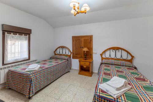 une chambre avec deux lits et une fenêtre dans l'établissement Casa De Los Abuelos, à Ortigosa del Monte