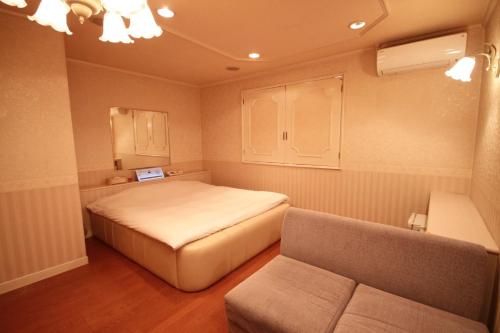 a small bedroom with a bed and a couch at Hotel An no Ie - Vacation STAY 80310v in Ikaho