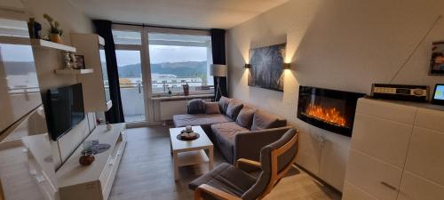 een woonkamer met een bank en een open haard bij Ferienwohnung Harzer Waldwichtel in Hahnenklee-Bockswiese