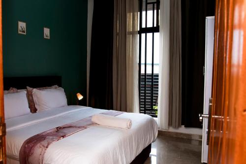 a bedroom with a large bed with a green wall at Natamber apartment in Rubavu