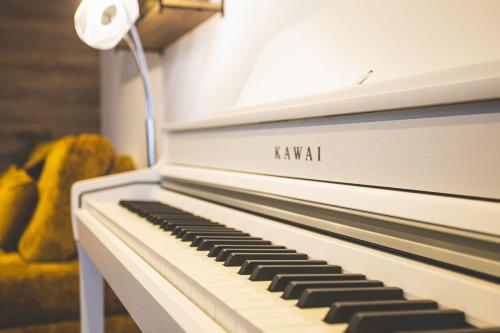 ein weißes Klavier mit den Worten „Kawi“ darauf in der Unterkunft Mas Lac Blanc Terrace Sauna Parking in Orbey