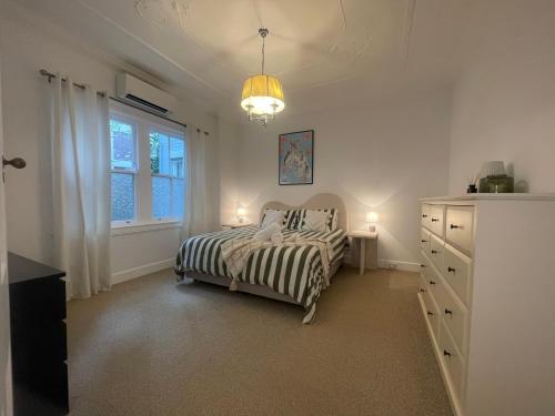 a bedroom with a bed and a dresser and a window at Luxury heritage Hideaway - close to CBD! in Sydney