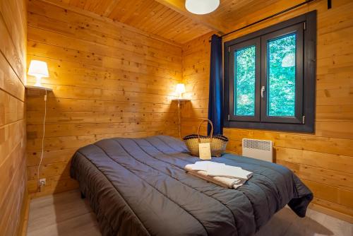 Burnhaupt-le-HautにあるCamping Alsace Les Castorsの木造キャビン内のベッド1台が備わるベッドルーム1室を利用します。