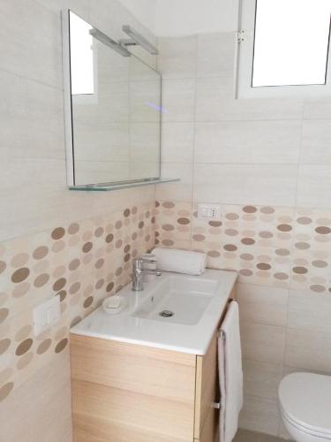 bagno con lavandino, specchio e servizi igienici di Nonna Titta Casa Vacanze a Matera